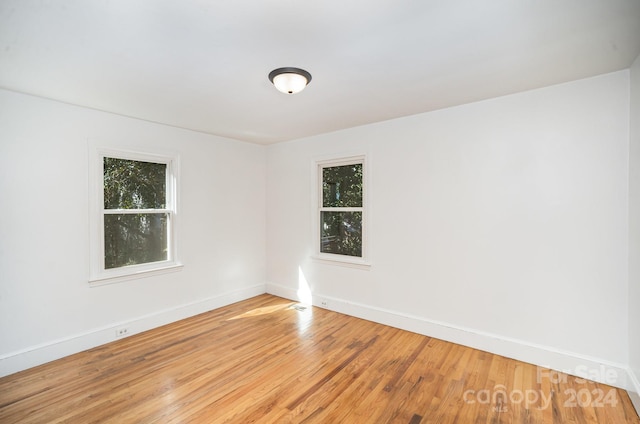 spare room with plenty of natural light and hardwood / wood-style flooring