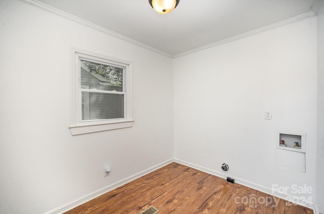 clothes washing area with wood-type flooring, hookup for a washing machine, and crown molding