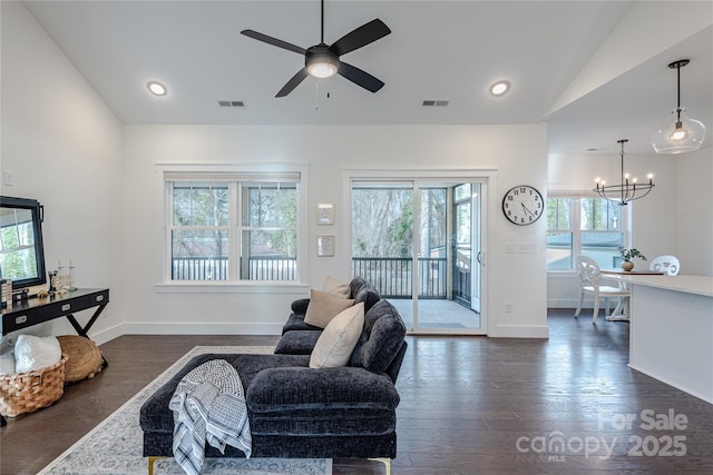 living room with lofted ceiling, dark hardwood / wood-style flooring, plenty of natural light, and ceiling fan with notable chandelier