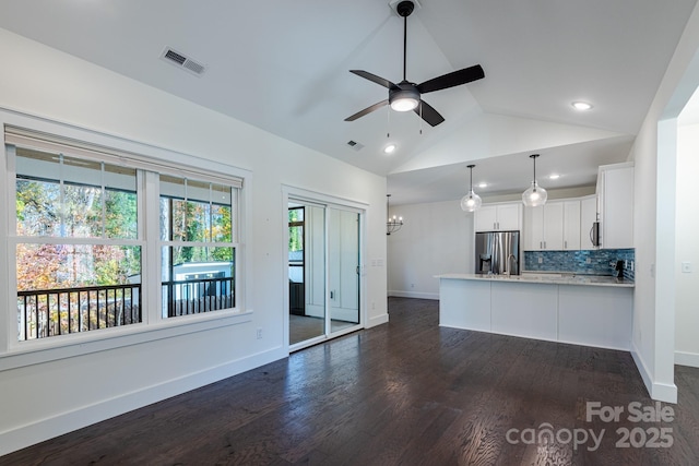 unfurnished living room featuring dark wood-type flooring, lofted ceiling, and ceiling fan with notable chandelier