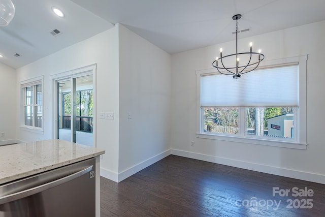 unfurnished dining area featuring dark wood-type flooring and a notable chandelier