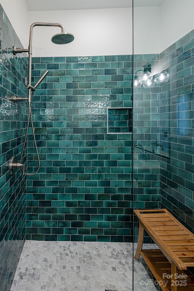 bathroom with tiled shower and tile patterned flooring