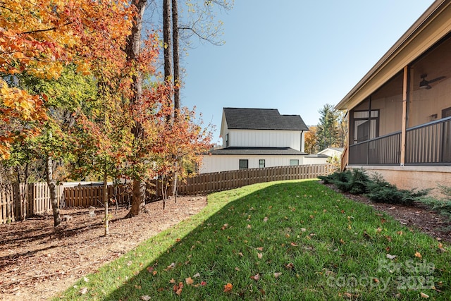 view of yard featuring ceiling fan and a sunroom