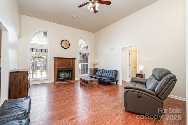 living room featuring ceiling fan, hardwood / wood-style floors, and high vaulted ceiling