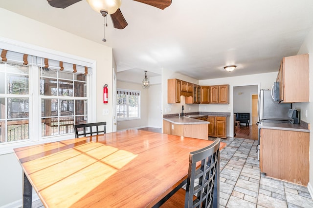 kitchen with kitchen peninsula, ceiling fan, and sink