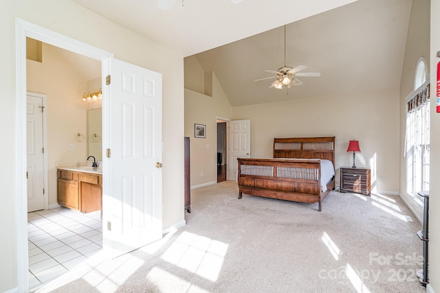 bedroom with connected bathroom, light carpet, sink, and high vaulted ceiling