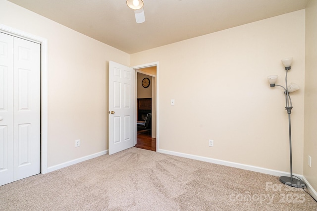 unfurnished bedroom featuring carpet, ceiling fan, and a closet