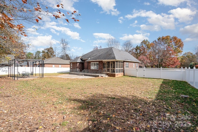 rear view of property featuring a lawn and a patio area