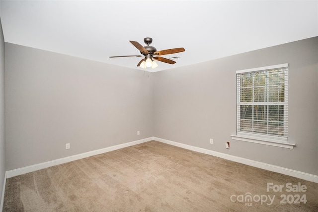 carpeted spare room featuring ceiling fan