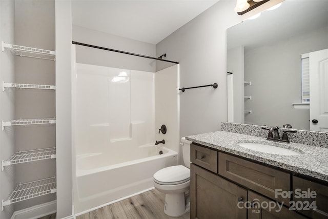 full bathroom featuring vanity, toilet, wood-type flooring, and shower / washtub combination