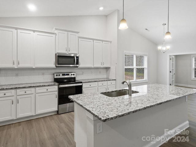 kitchen featuring tasteful backsplash, stainless steel appliances, hanging light fixtures, sink, and white cabinets