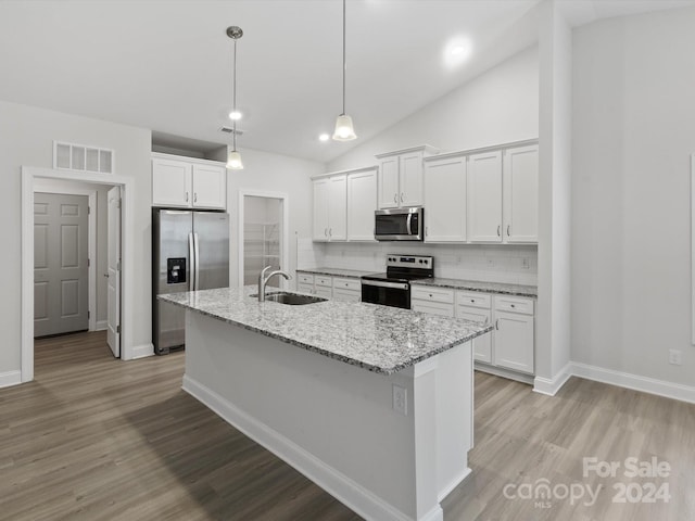 kitchen featuring stainless steel appliances, white cabinetry, sink, tasteful backsplash, and vaulted ceiling