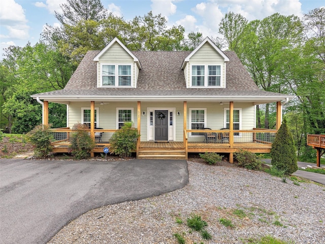 farmhouse-style home with a porch and roof with shingles