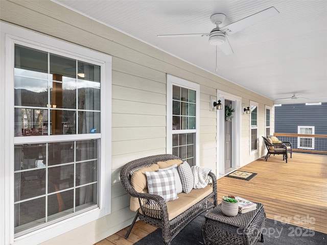 wooden terrace with a porch and a ceiling fan