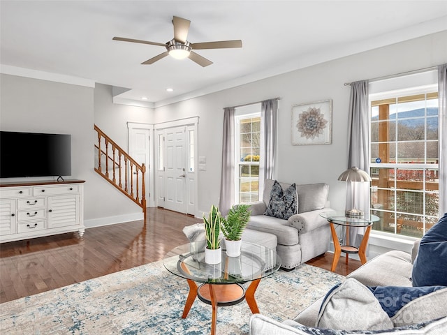 living room with ceiling fan, a healthy amount of sunlight, wood finished floors, and stairway