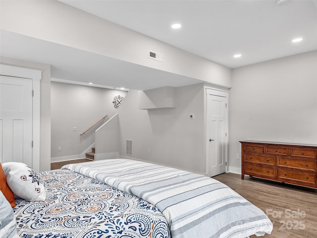 bedroom with recessed lighting, visible vents, and wood finished floors