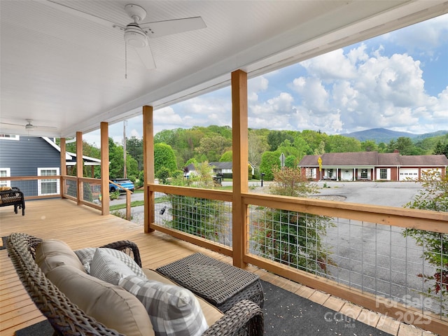 deck with ceiling fan, outdoor lounge area, and a mountain view