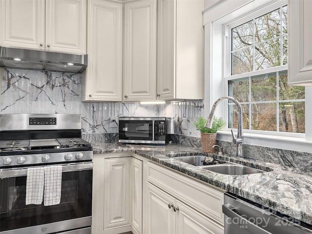 kitchen featuring decorative backsplash, a sink, white cabinets, under cabinet range hood, and stainless steel appliances