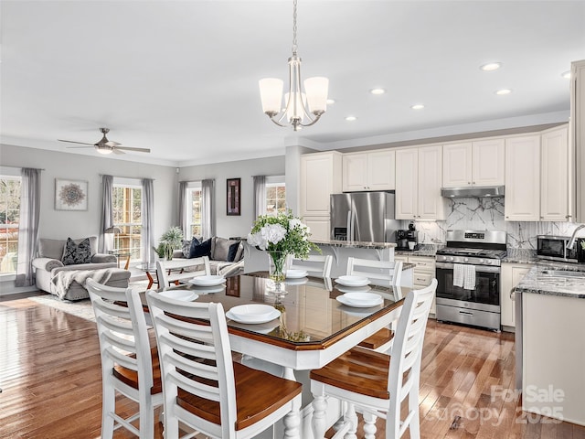 dining space featuring recessed lighting, ceiling fan with notable chandelier, and light wood-type flooring