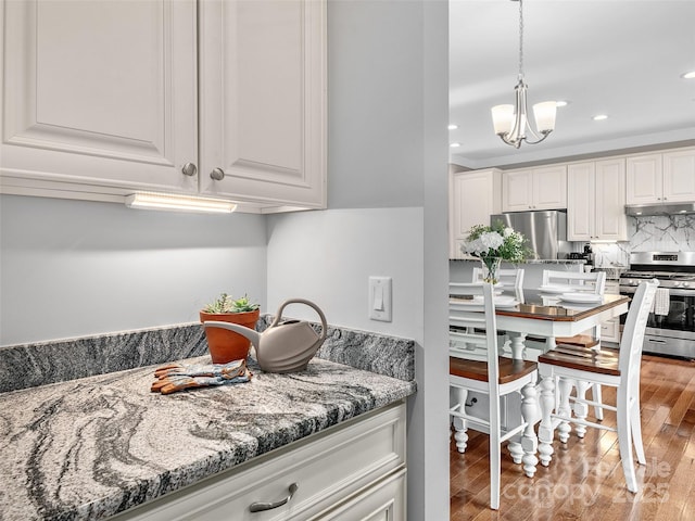 kitchen with white cabinets, a chandelier, stainless steel appliances, recessed lighting, and under cabinet range hood