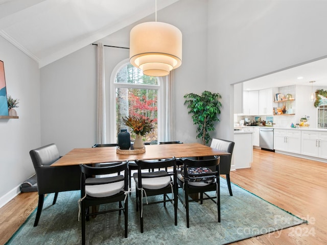 dining space featuring light hardwood / wood-style flooring, lofted ceiling, and ornamental molding