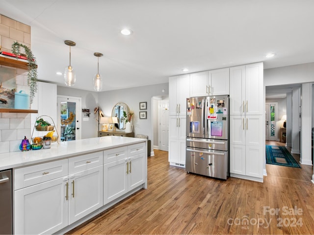 kitchen featuring stainless steel fridge and white cabinetry