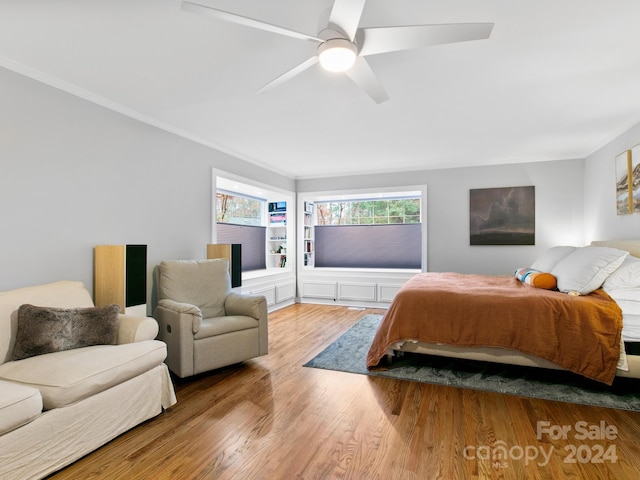 bedroom featuring light hardwood / wood-style floors, ceiling fan, and crown molding