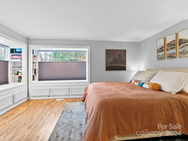 bedroom featuring ornamental molding and light hardwood / wood-style floors