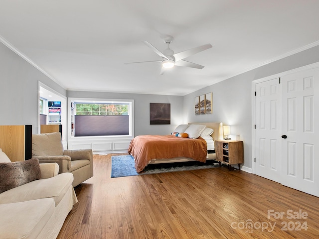 bedroom with hardwood / wood-style floors, ceiling fan, and ornamental molding