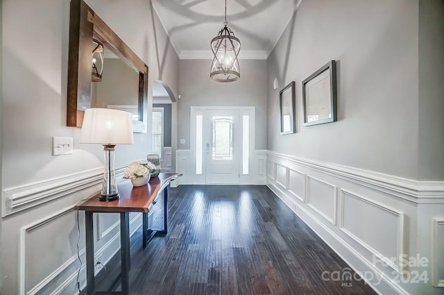 doorway to outside featuring crown molding, dark hardwood / wood-style flooring, and a chandelier