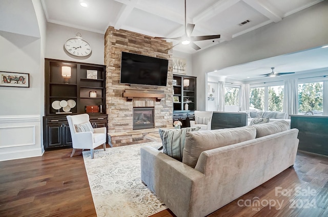 living room with a fireplace, beamed ceiling, ceiling fan, and dark wood-type flooring