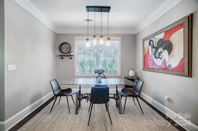 dining room featuring hardwood / wood-style floors and crown molding