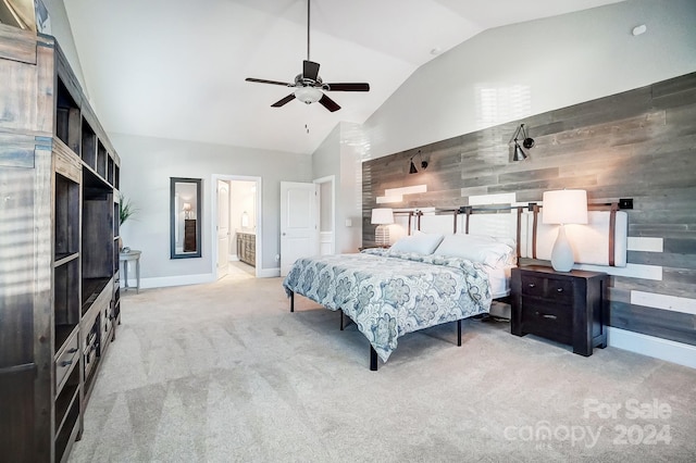 bedroom with ensuite bath, ceiling fan, high vaulted ceiling, wood walls, and light carpet