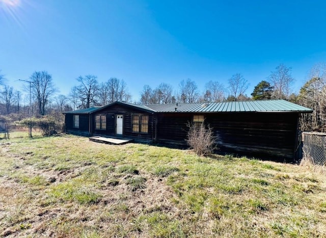 rear view of property featuring a lawn