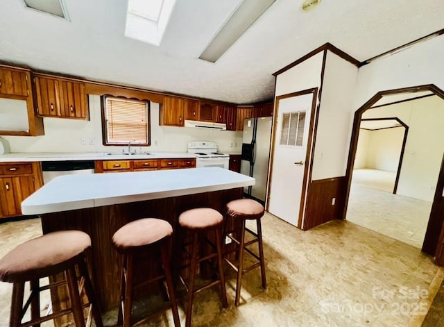 kitchen featuring sink, a center island, extractor fan, and appliances with stainless steel finishes