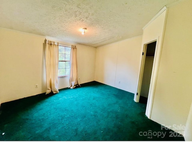 carpeted empty room featuring a textured ceiling