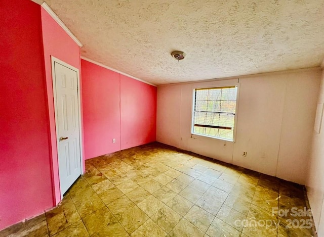 empty room featuring crown molding and a textured ceiling