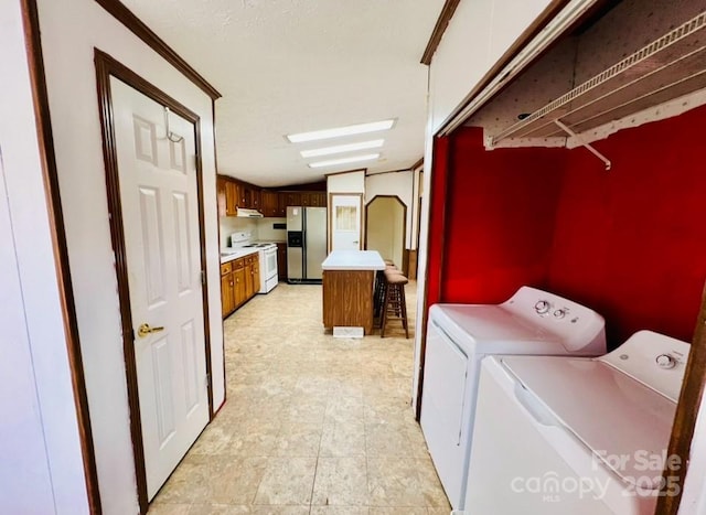 washroom with washer and dryer and crown molding