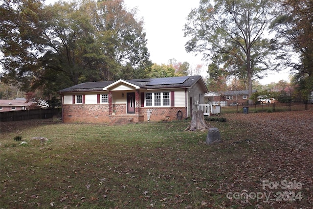 view of front of home featuring solar panels and a front yard