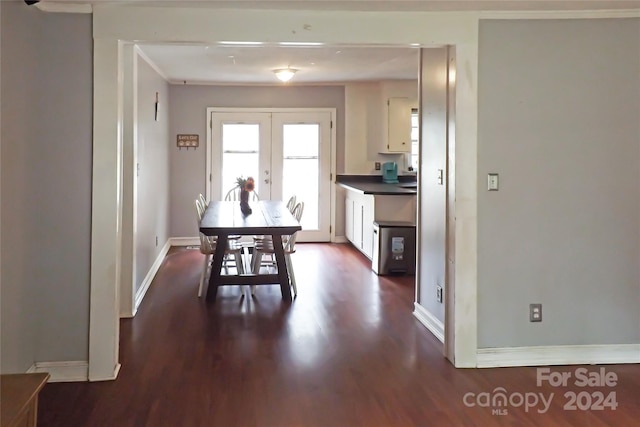 dining area featuring dark wood-type flooring, crown molding, and french doors