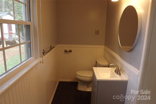 bathroom featuring hardwood / wood-style floors, a wealth of natural light, vanity, and toilet