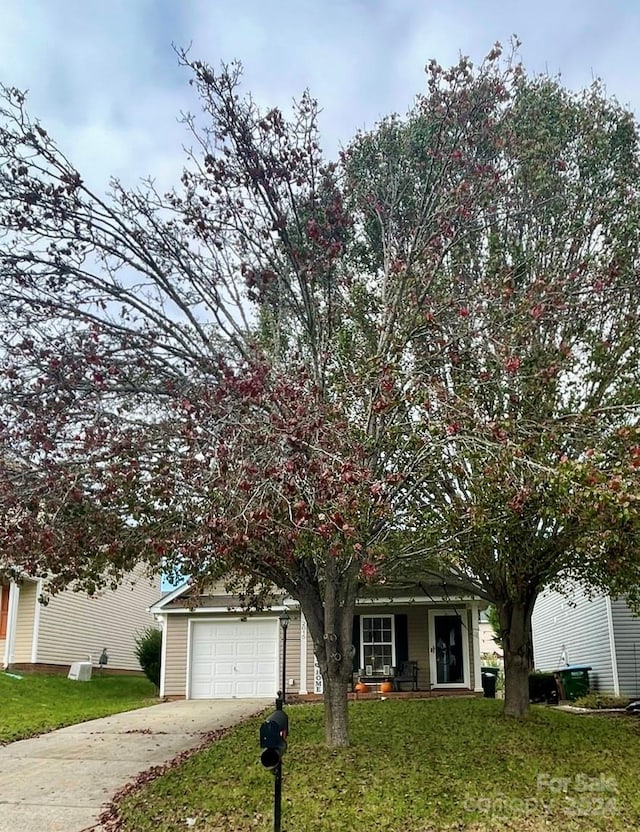 obstructed view of property featuring a garage and a front yard