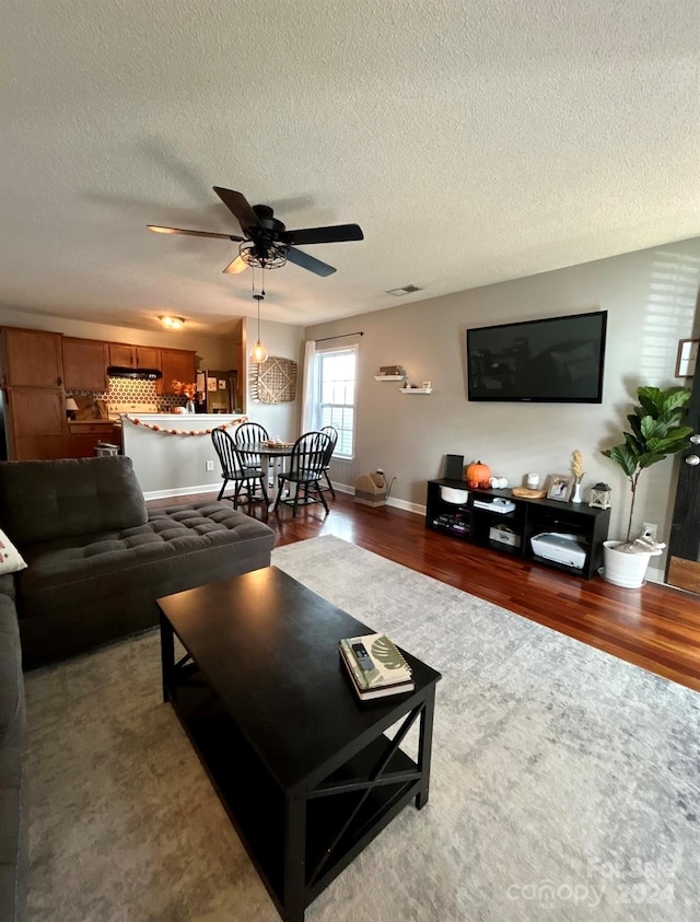 living room with wood-type flooring, a textured ceiling, and ceiling fan