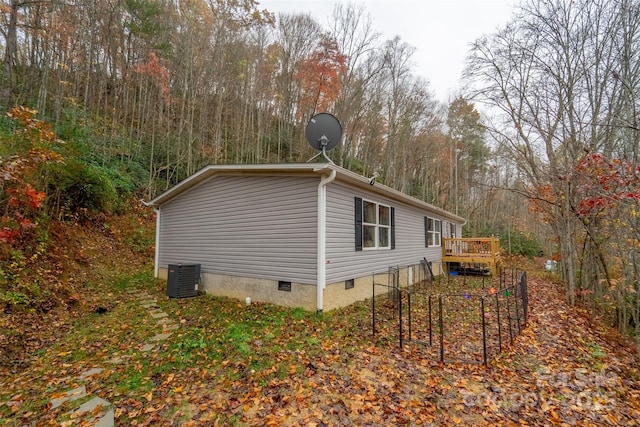 view of side of property with central AC and a deck