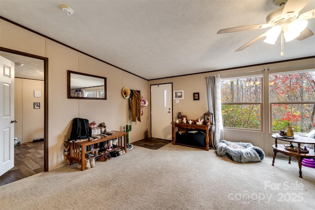 sitting room with carpet, ceiling fan, a textured ceiling, and vaulted ceiling