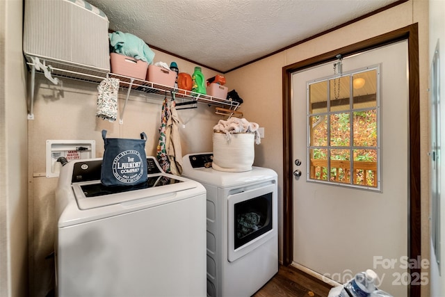 clothes washing area with a textured ceiling, dark hardwood / wood-style floors, ornamental molding, and washing machine and clothes dryer