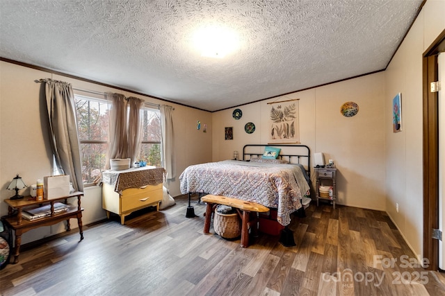 bedroom with a textured ceiling, hardwood / wood-style flooring, and ornamental molding