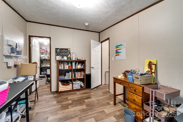 home office with a textured ceiling, hardwood / wood-style flooring, and ornamental molding