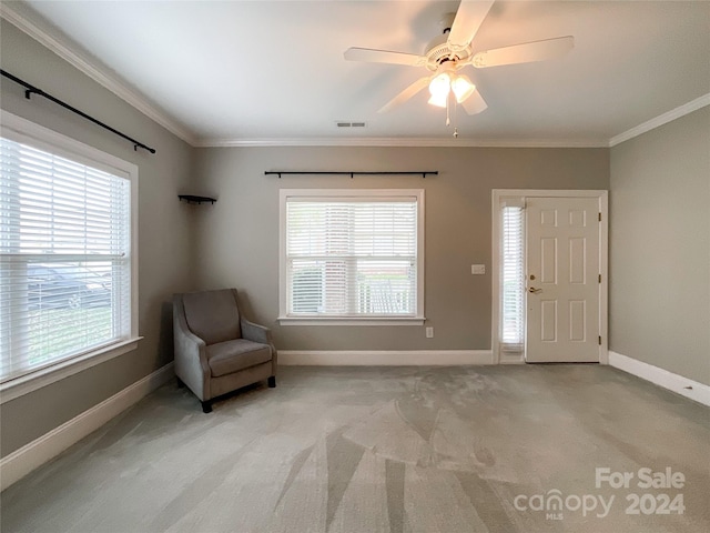 unfurnished room with ceiling fan, a wealth of natural light, light colored carpet, and ornamental molding