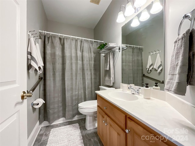 bathroom with toilet, vanity, and tile patterned flooring